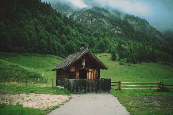 brown wooden house surrounded by grass